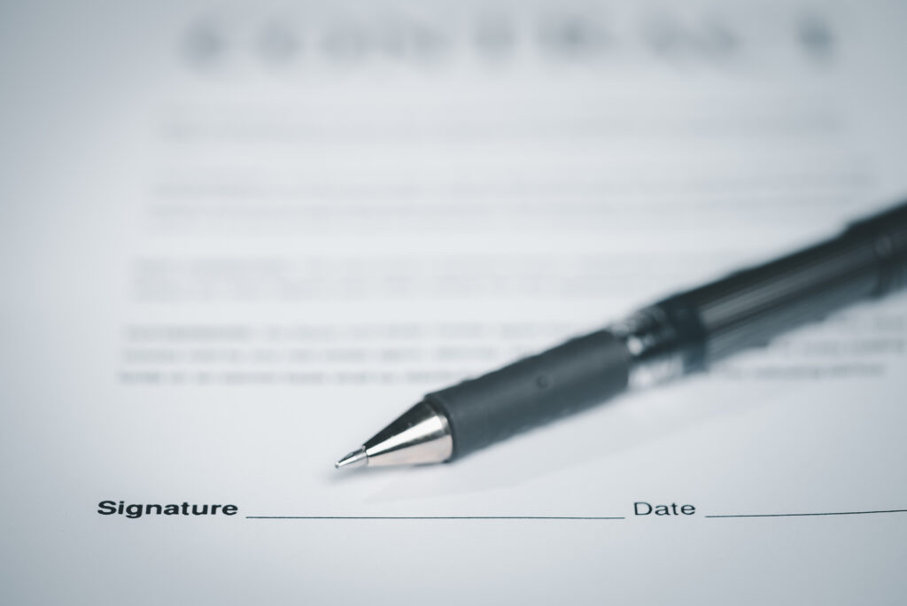 A close-up of a pen resting on a contract form, symbolizing agreement and legal documentation.