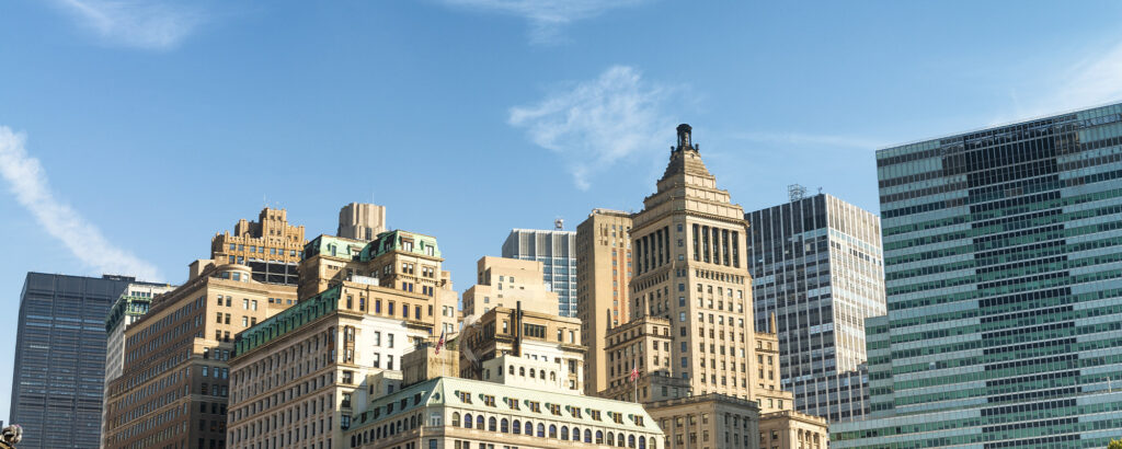 A bustling city street featuring tall buildings and a prominent clock tower in the background.