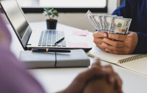 The young man waited to receive salary or wages from the boss. Businessman holding cash banknotes in the office.